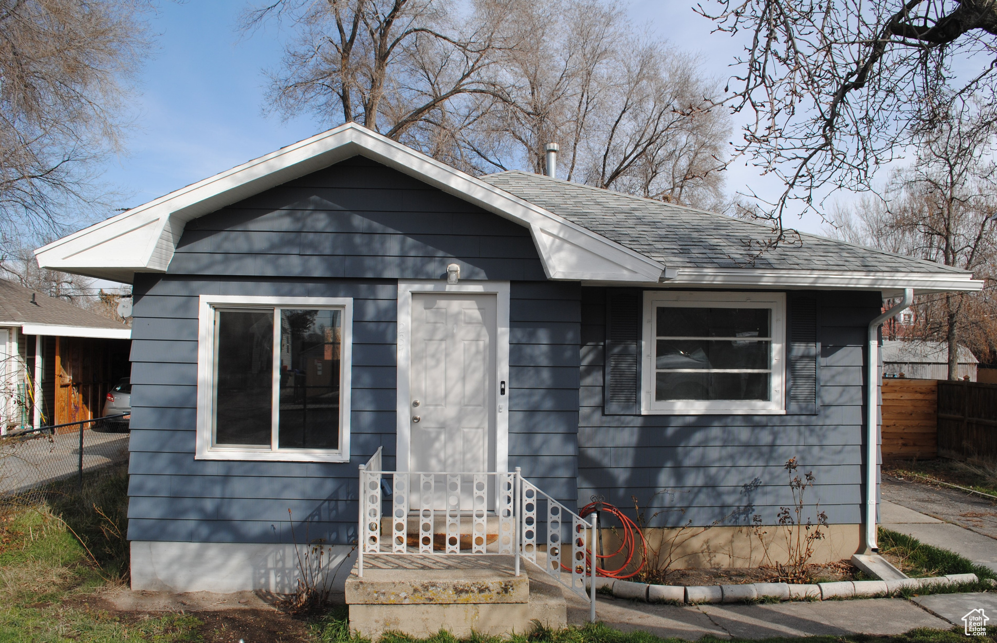 Bungalow with roof with shingles and fence