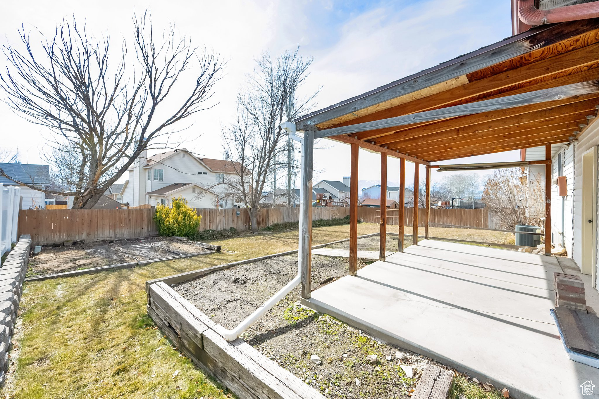 View of yard featuring a residential view, a garden, a fenced backyard, and central AC unit