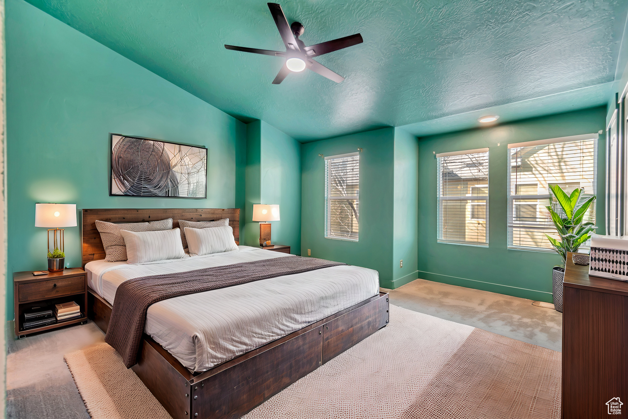 Bedroom featuring light carpet, baseboards, a ceiling fan, vaulted ceiling, and a textured ceiling