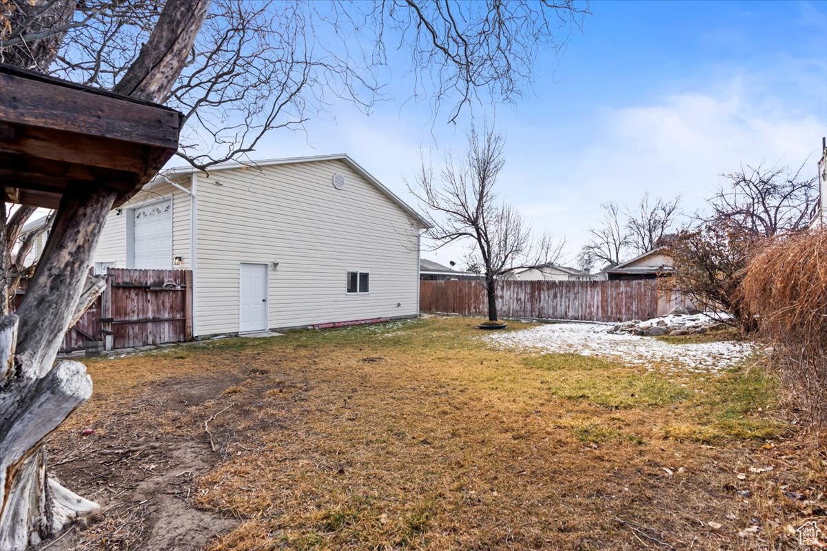 View of side of property featuring a yard and fence