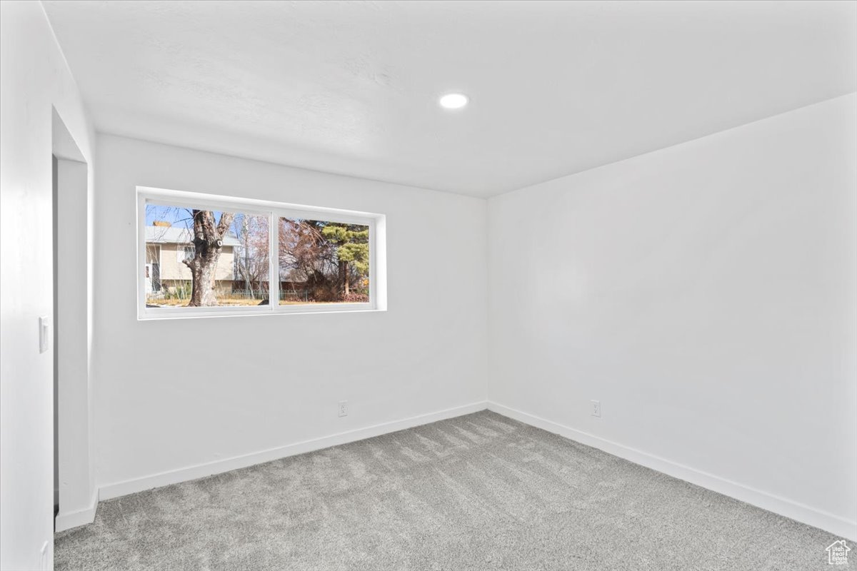Unfurnished room with baseboards, recessed lighting, and light colored carpet