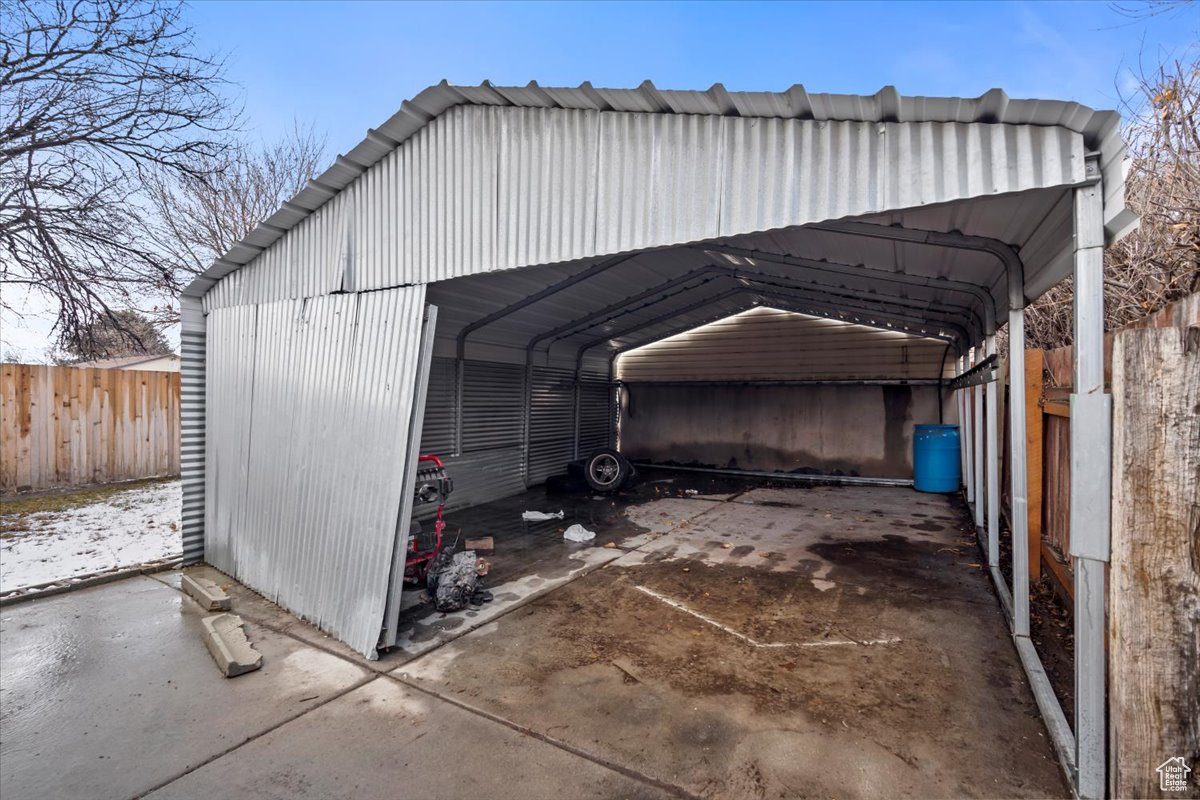 View of outbuilding with fence and a detached carport