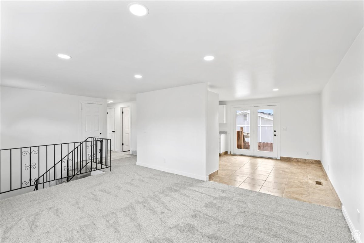 Spare room with recessed lighting, light carpet, visible vents, and baseboards