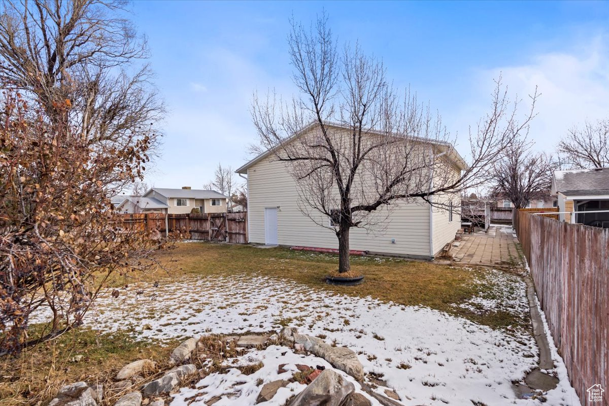 View of snowy exterior featuring a fenced backyard