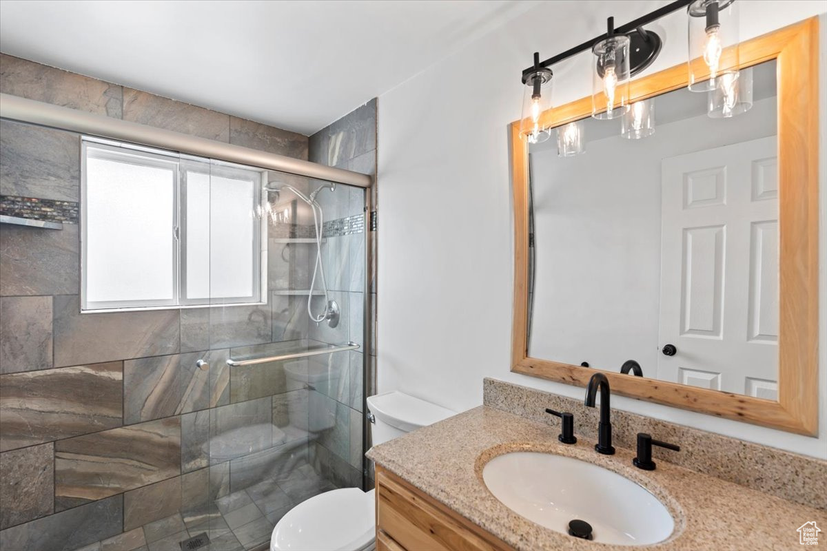 Full bathroom with a stall shower, vanity, and toilet