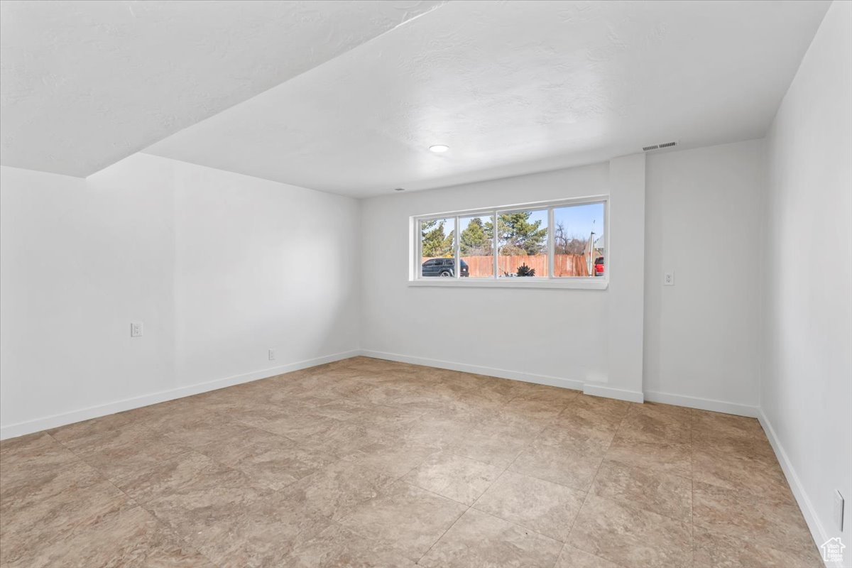 Empty room with visible vents and baseboards