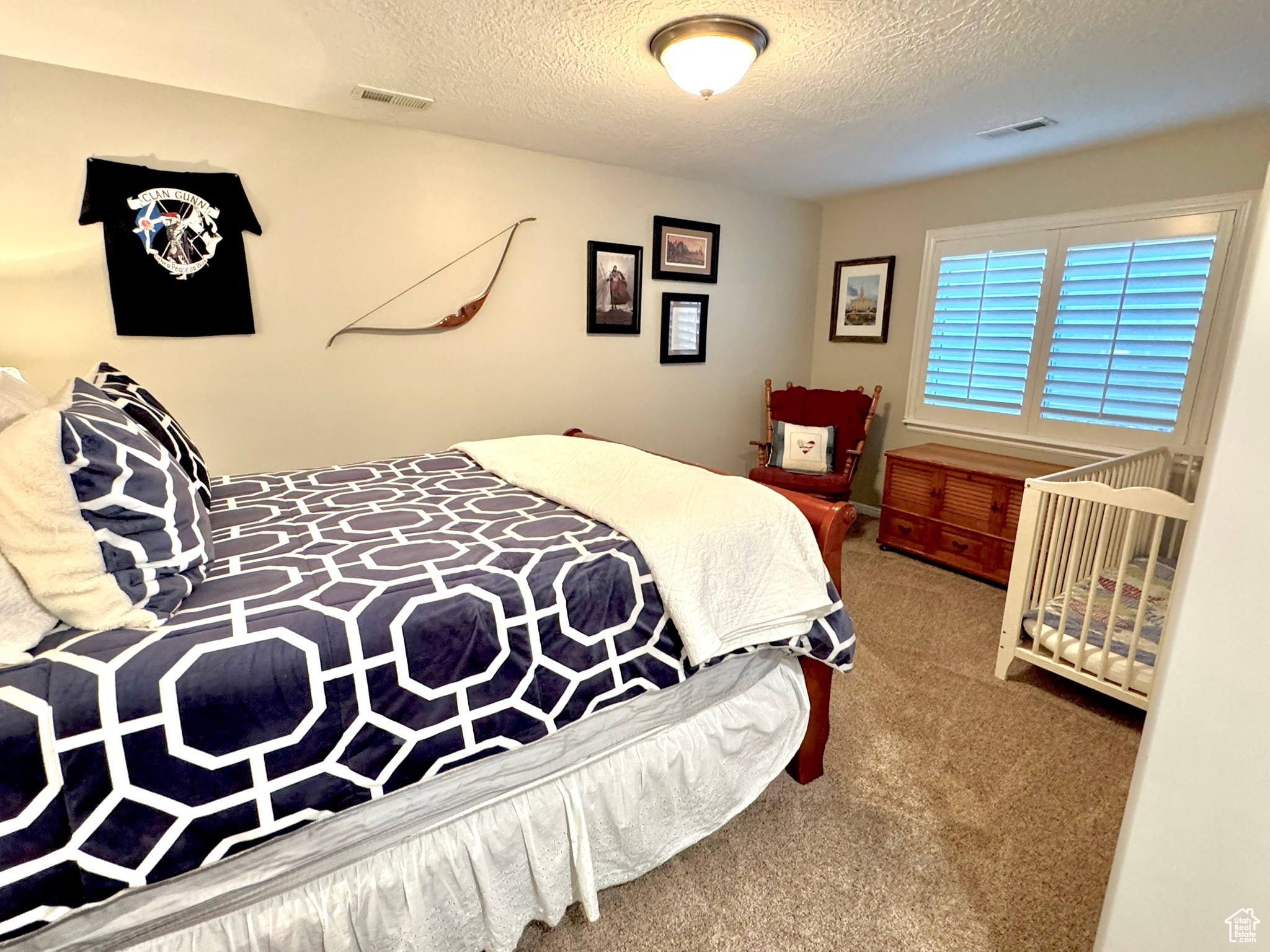 Bedroom 4 with carpet, visible vents, and a textured ceiling