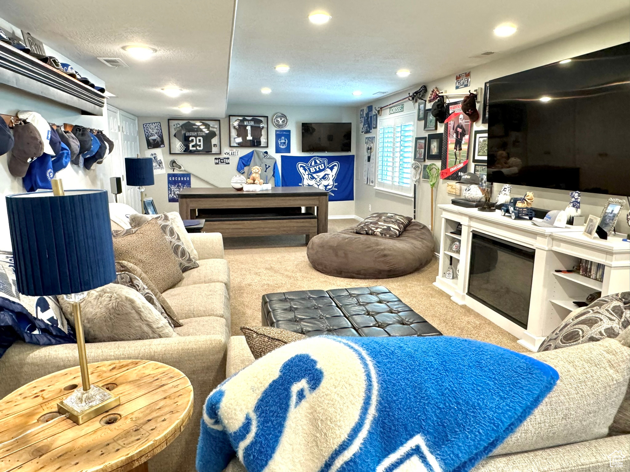 Living room with recessed lighting, light colored carpet, and a glass covered fireplace