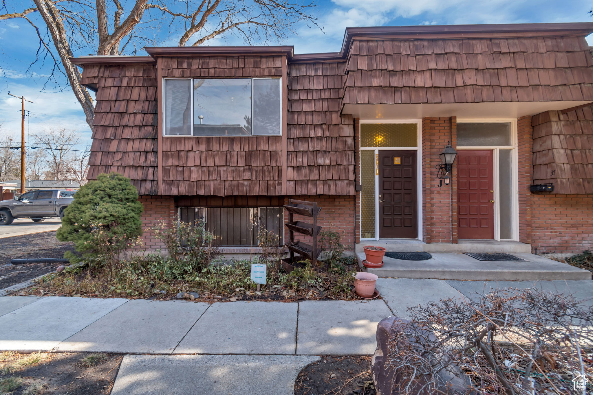 View of front of property featuring mansard roof and brick siding