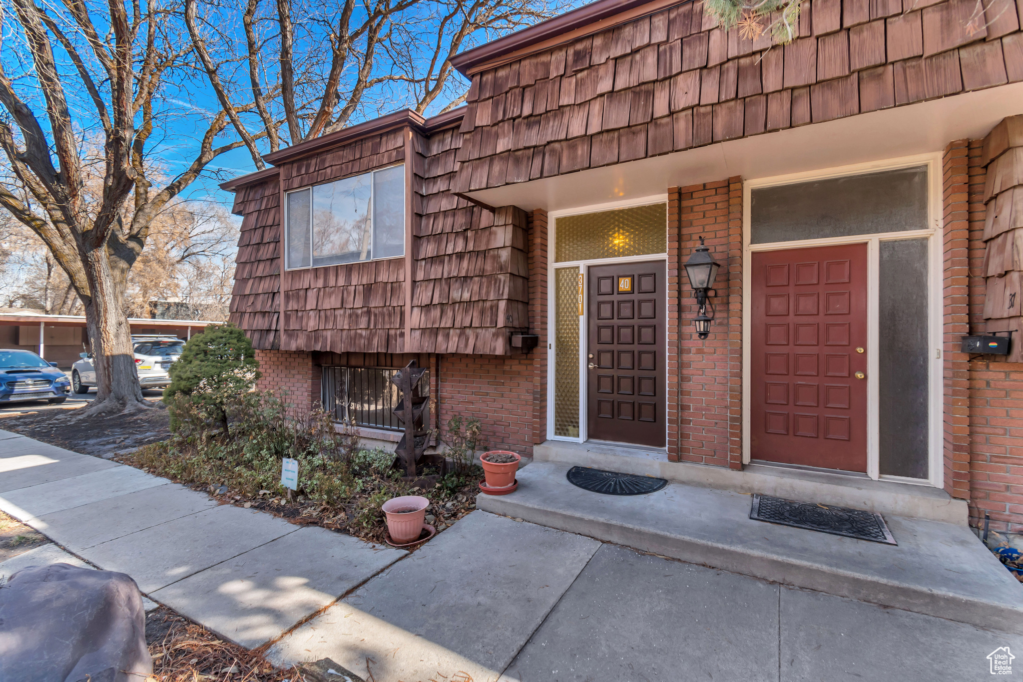 Doorway to property featuring brick siding and mansard roof