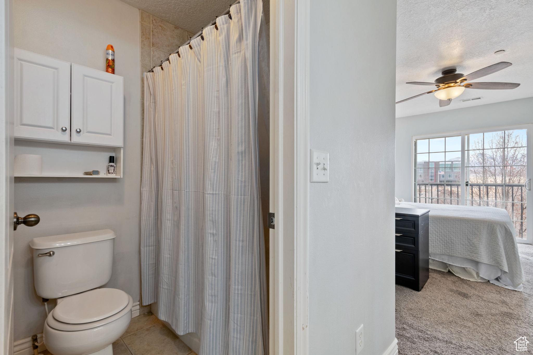 Ensuite bathroom with ensuite bathroom, a textured ceiling, tile patterned flooring, toilet, and a ceiling fan