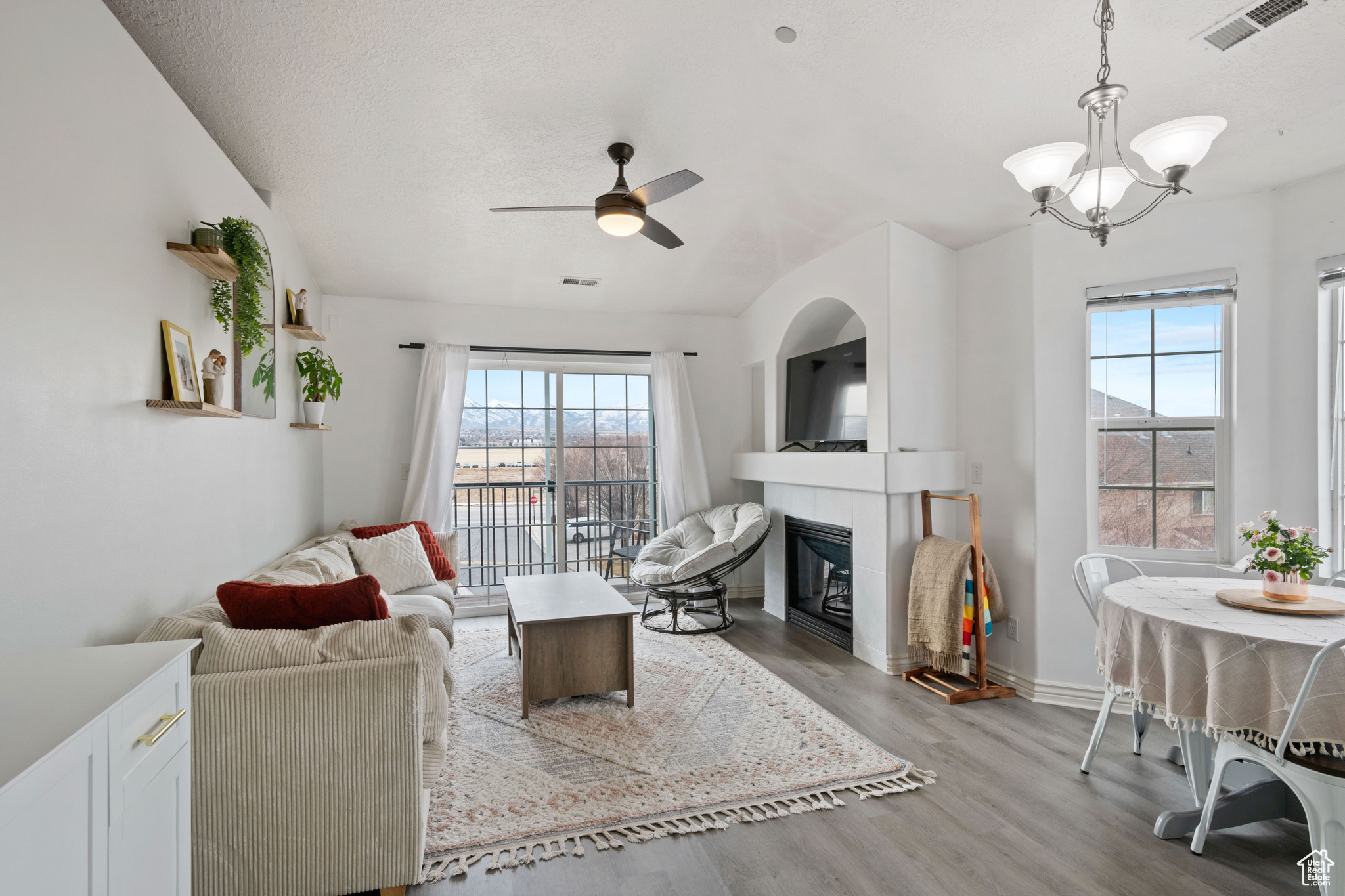 Living area with light wood-style floors, a healthy amount of sunlight, visible vents, and a fireplace