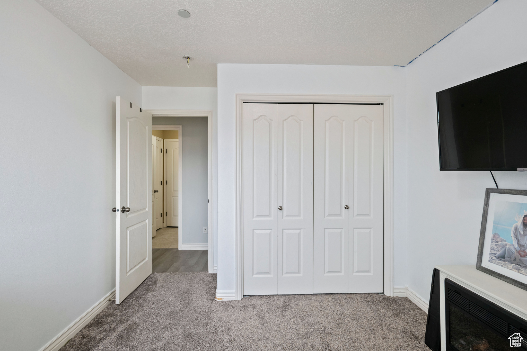Unfurnished bedroom with baseboards, a closet, and light colored carpet