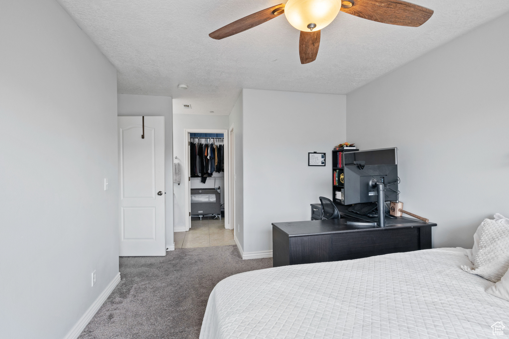Bedroom with light colored carpet, ceiling fan, a textured ceiling, and baseboards
