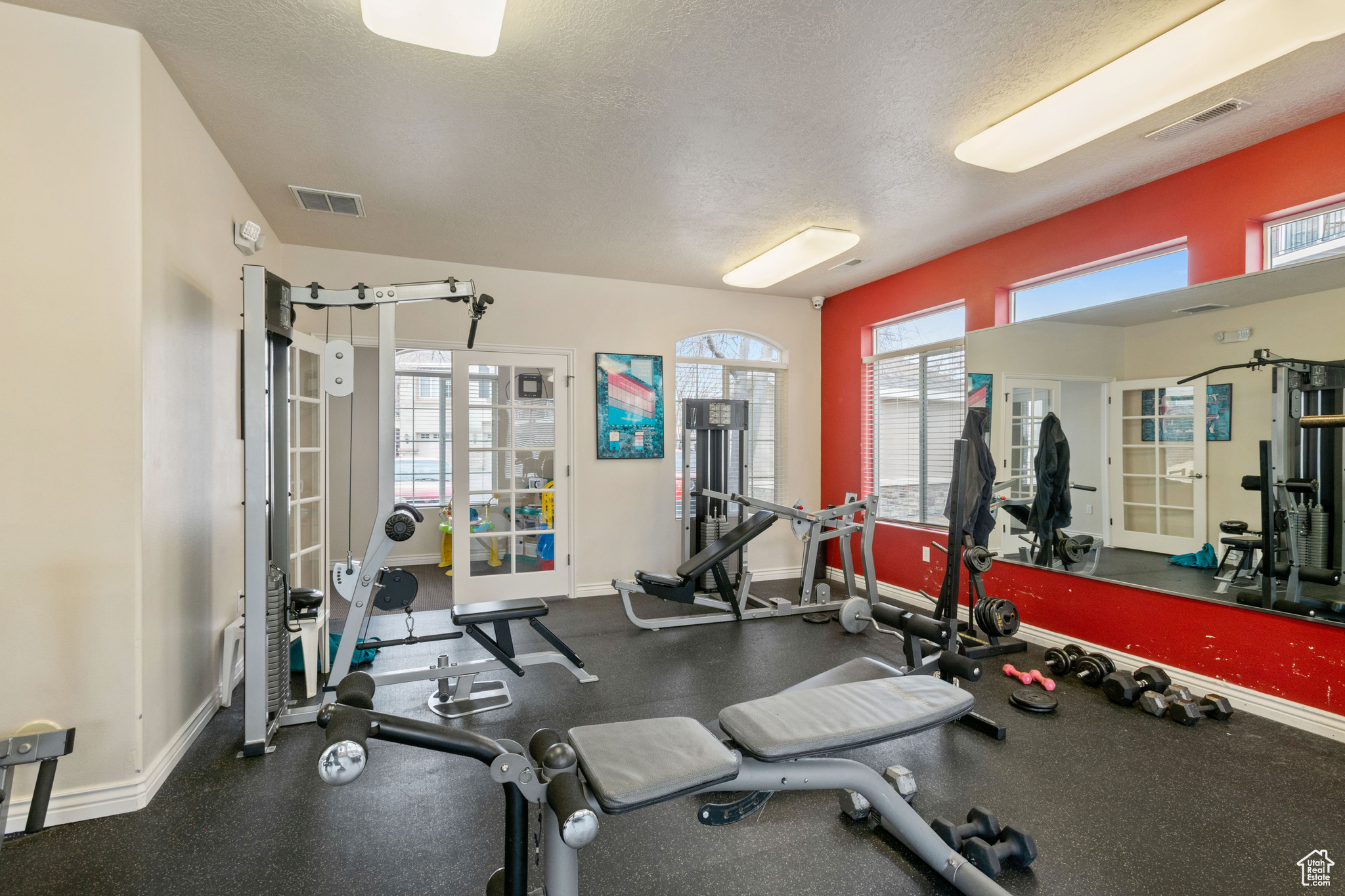 Gym featuring a textured ceiling, visible vents, and baseboards