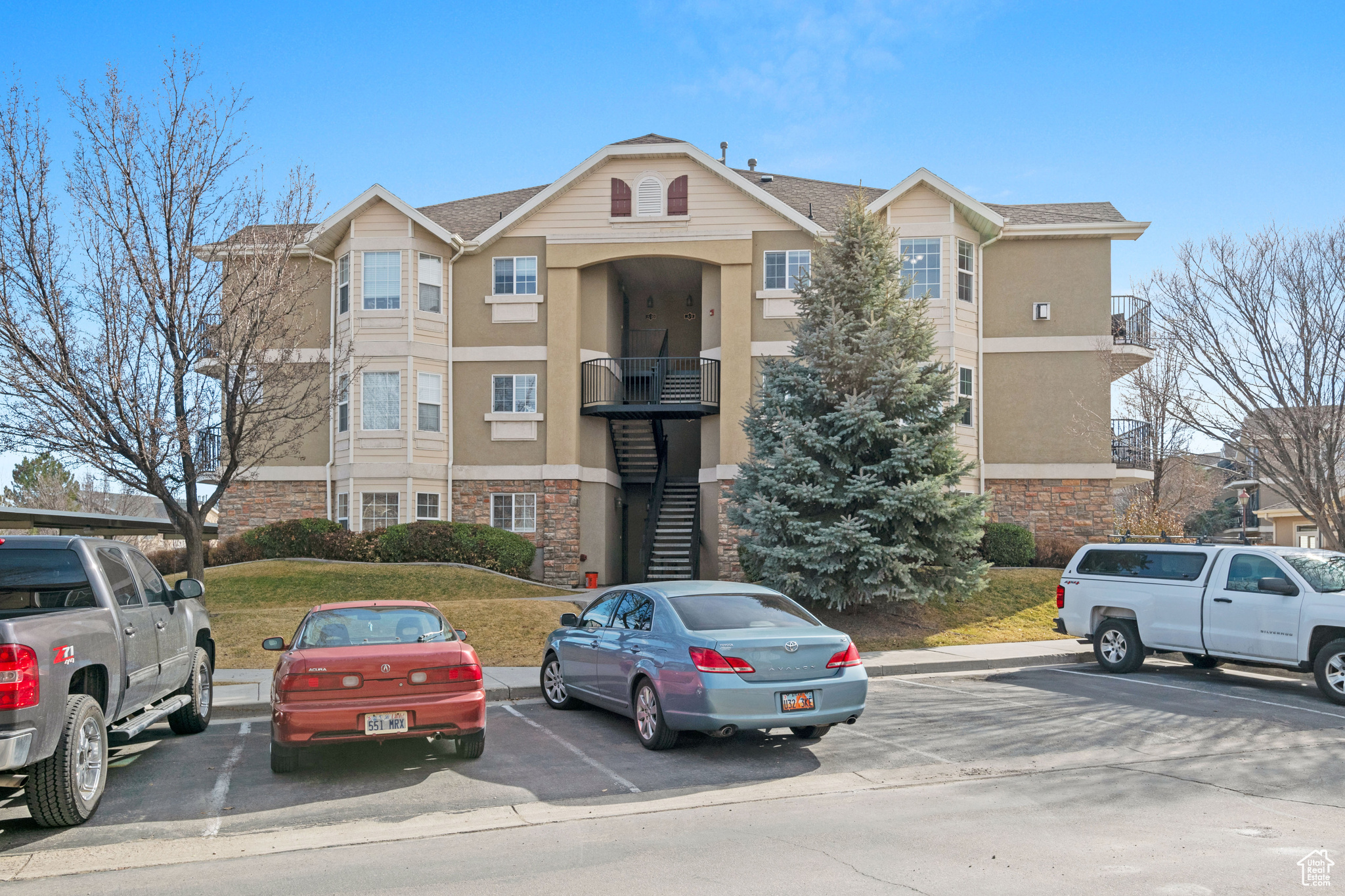 View of building exterior featuring stairs and uncovered parking