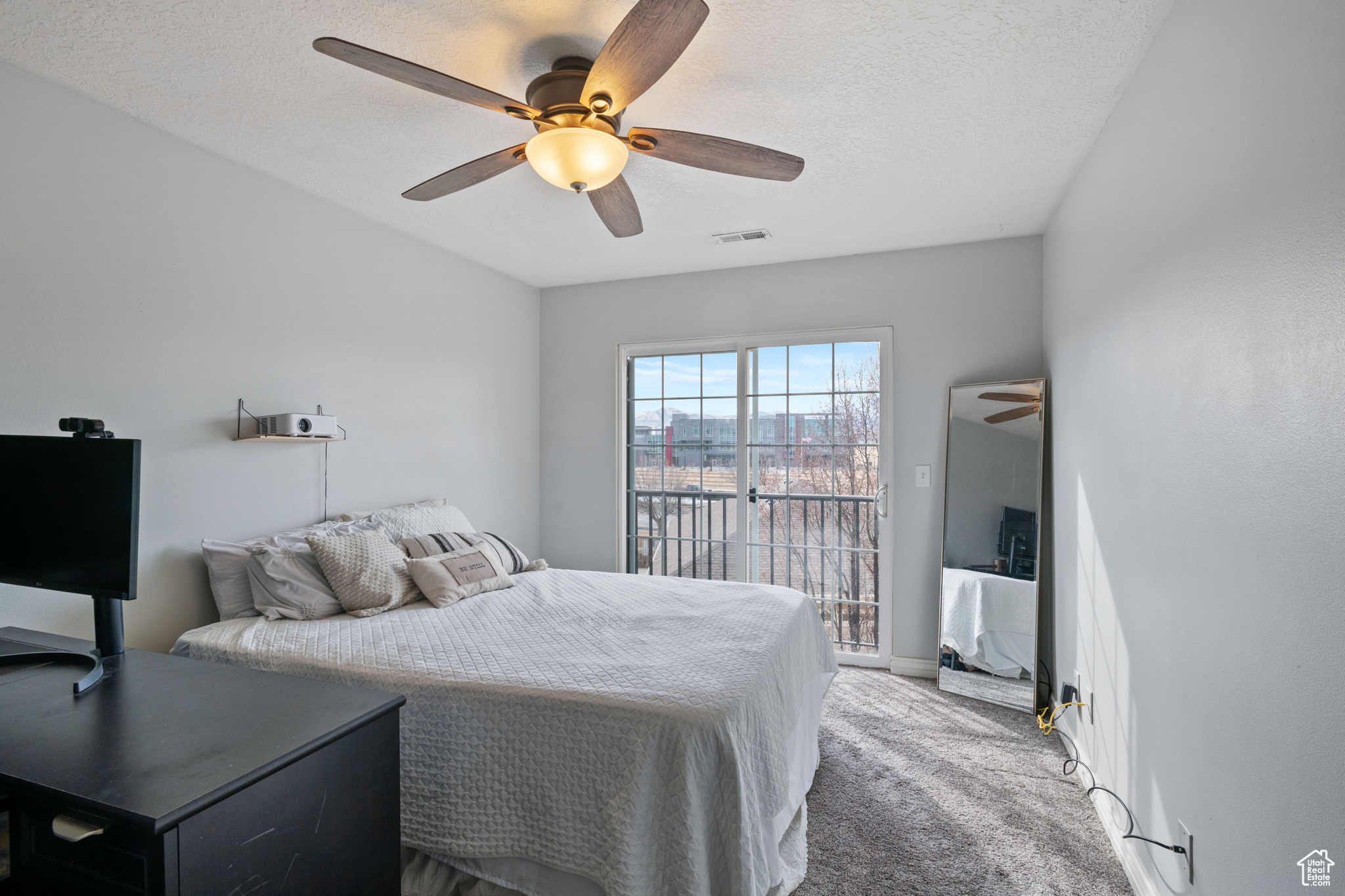 Bedroom with a textured ceiling, ceiling fan, visible vents, access to exterior, and carpet