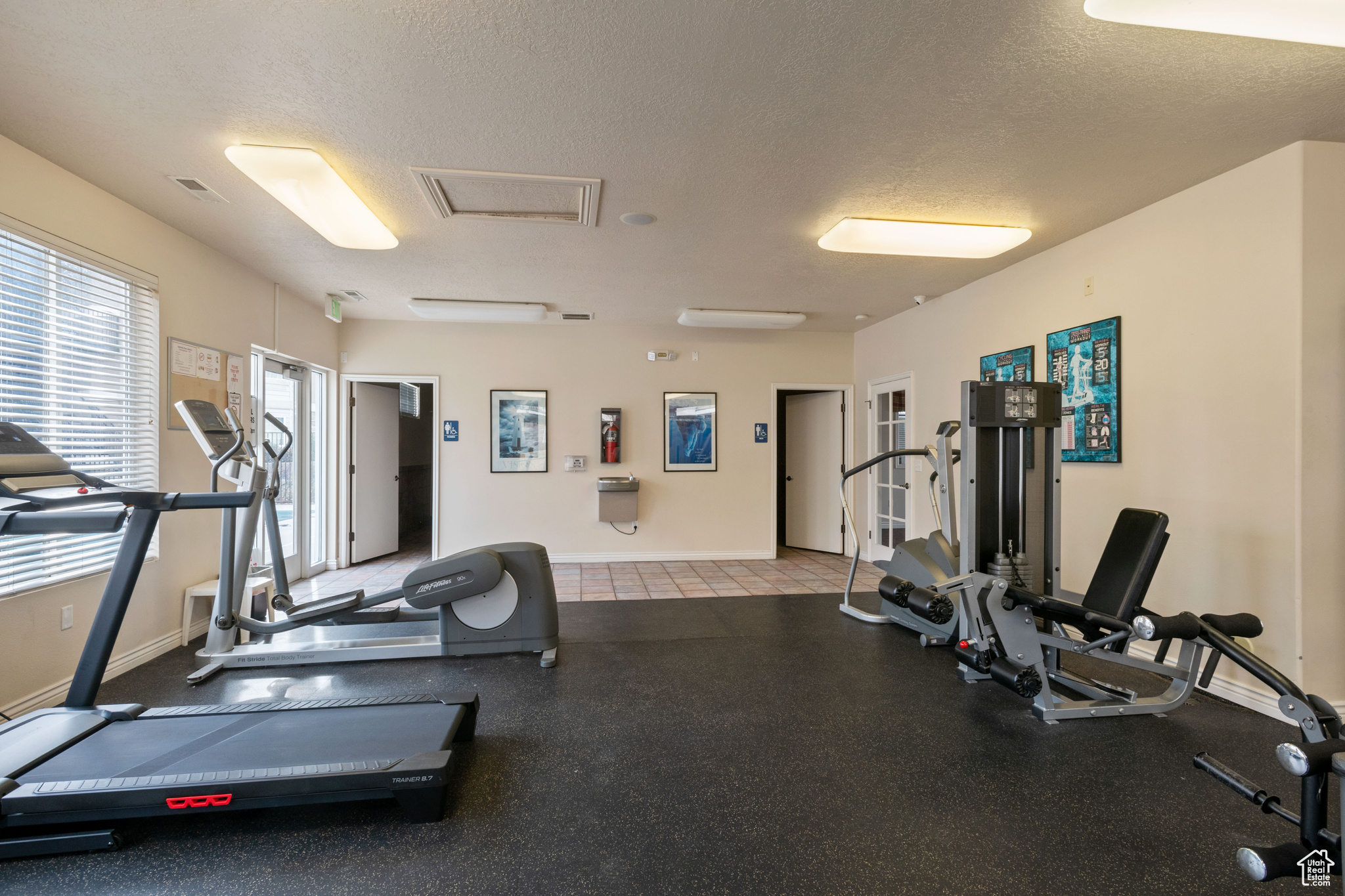 Exercise room with baseboards and a textured ceiling