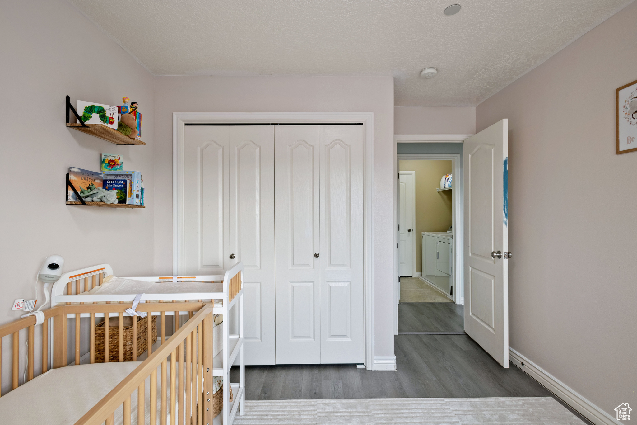 Bedroom with dark wood-style floors, a closet, and baseboards