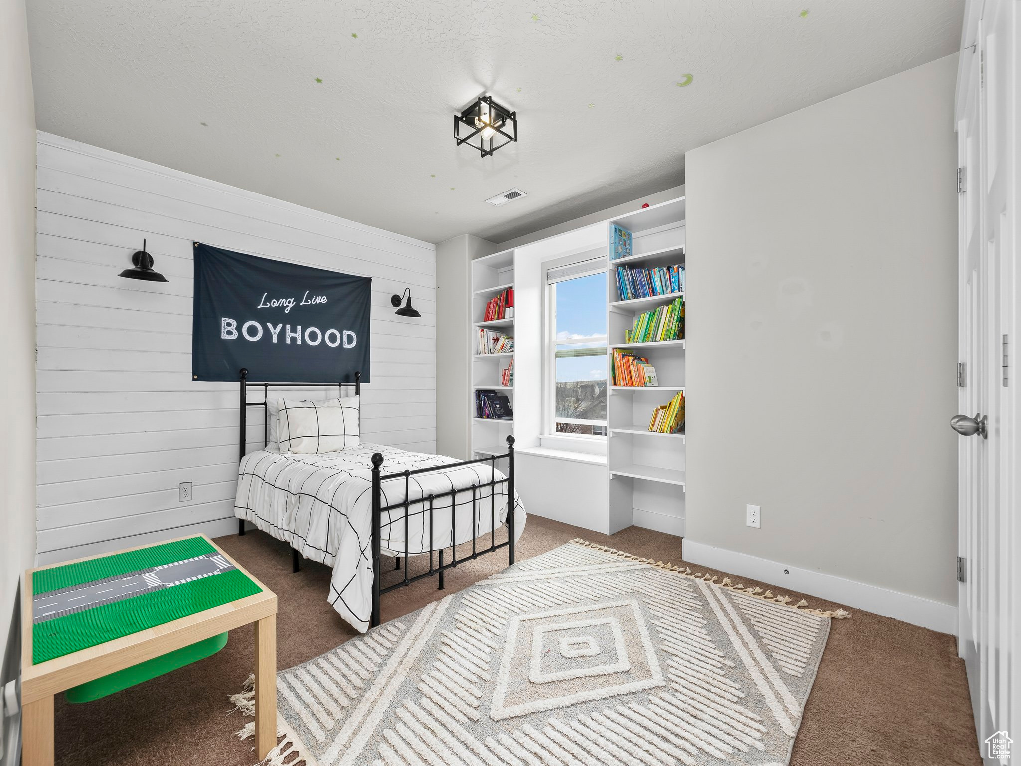 Bedroom featuring wood walls, carpet flooring, visible vents, and baseboards
