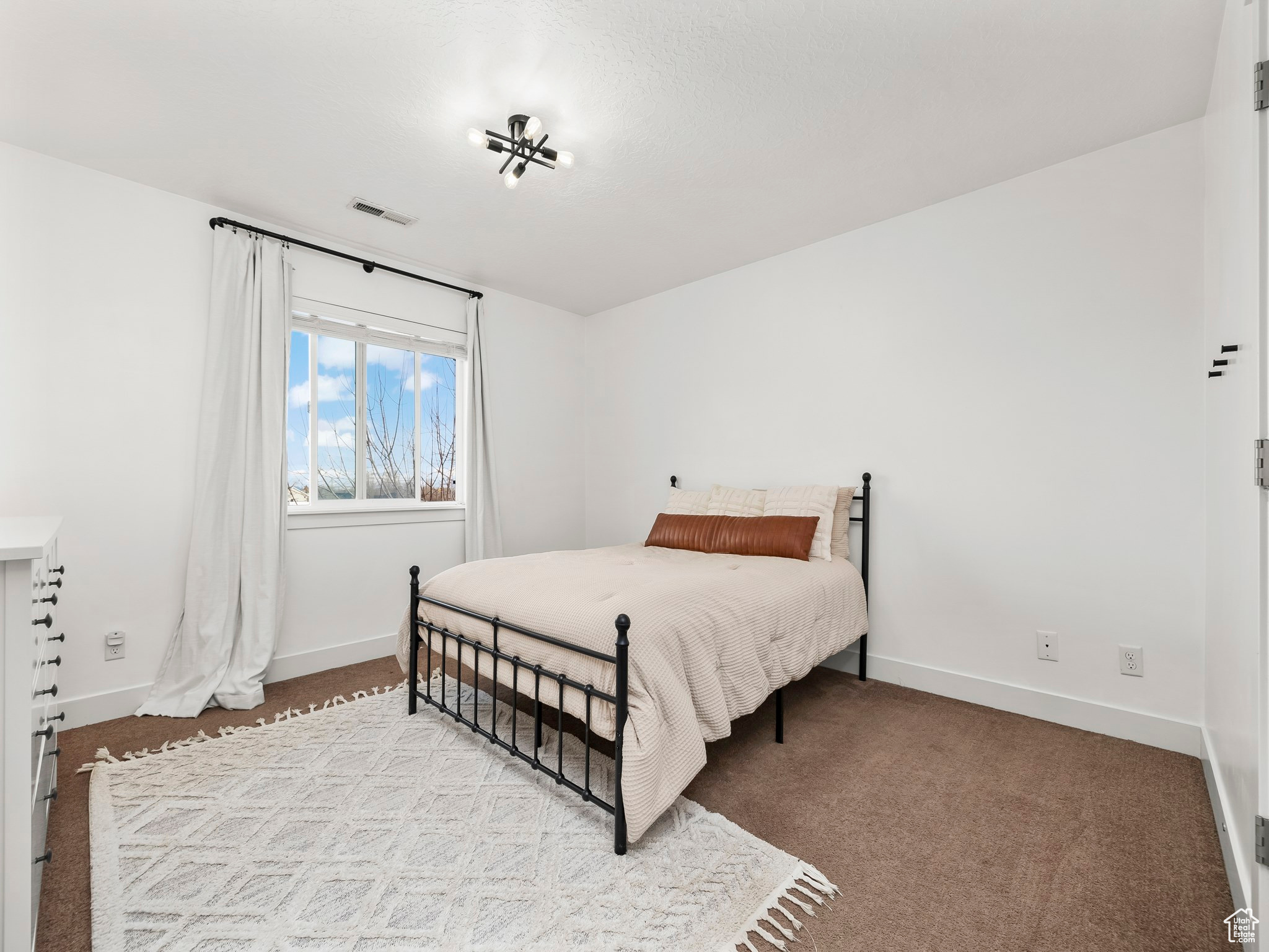 Bedroom with light colored carpet, visible vents, and baseboards