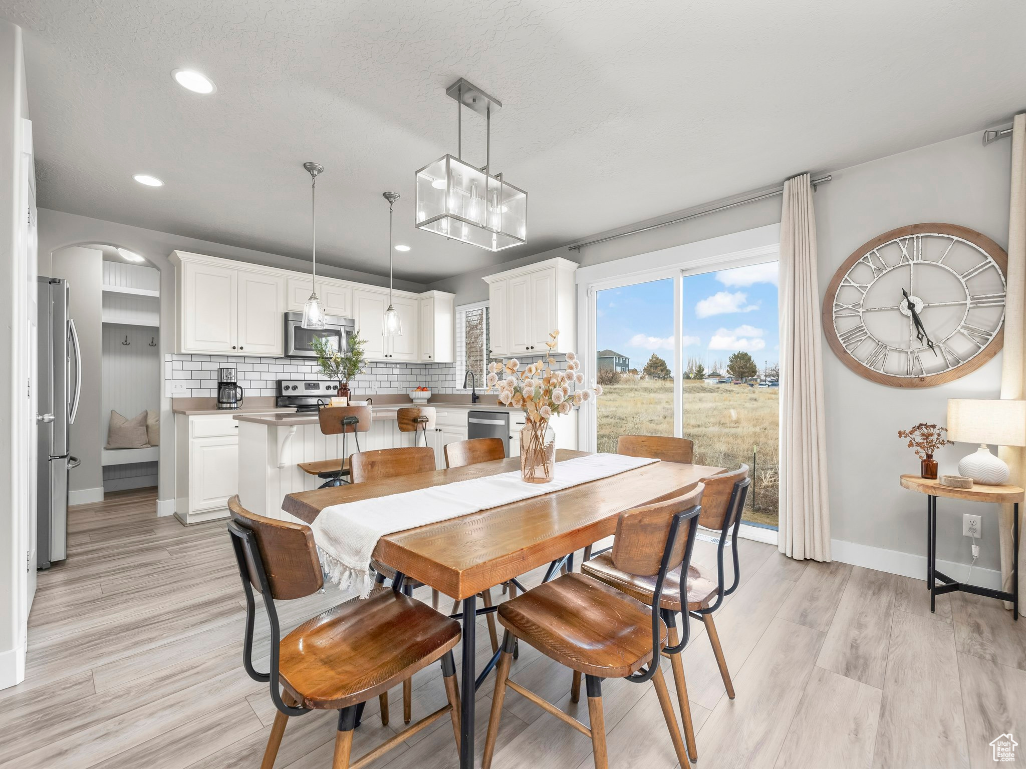 Dining area featuring arched walkways, recessed lighting, baseboards, and light wood-style floors