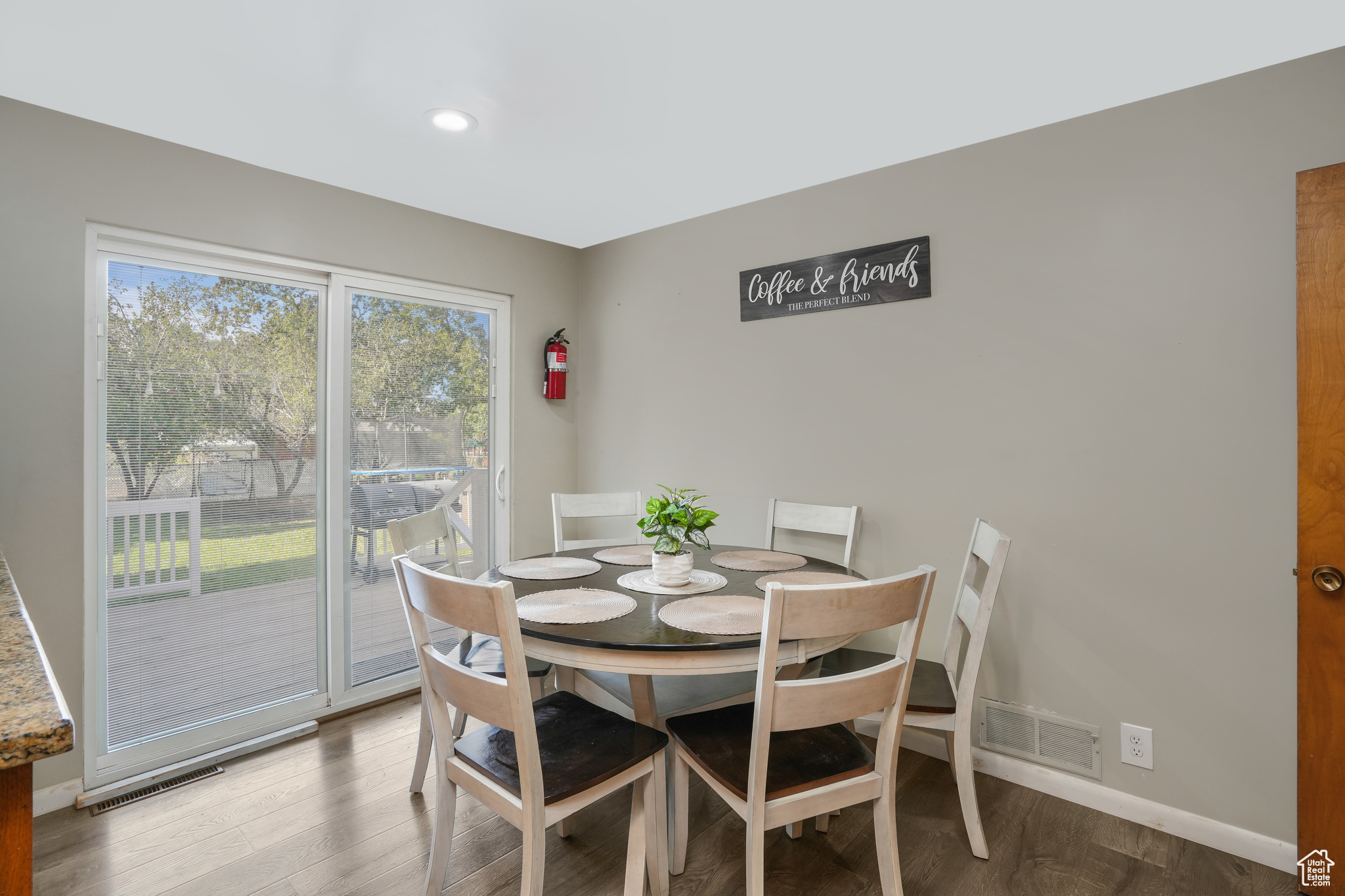 Dining space with wood finished floors, visible vents, and baseboards