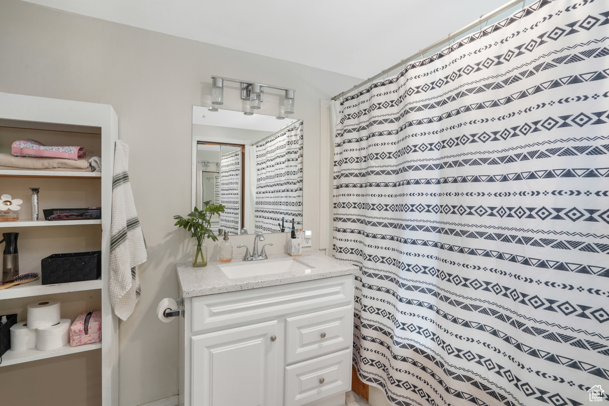 Full bathroom featuring curtained shower and vanity