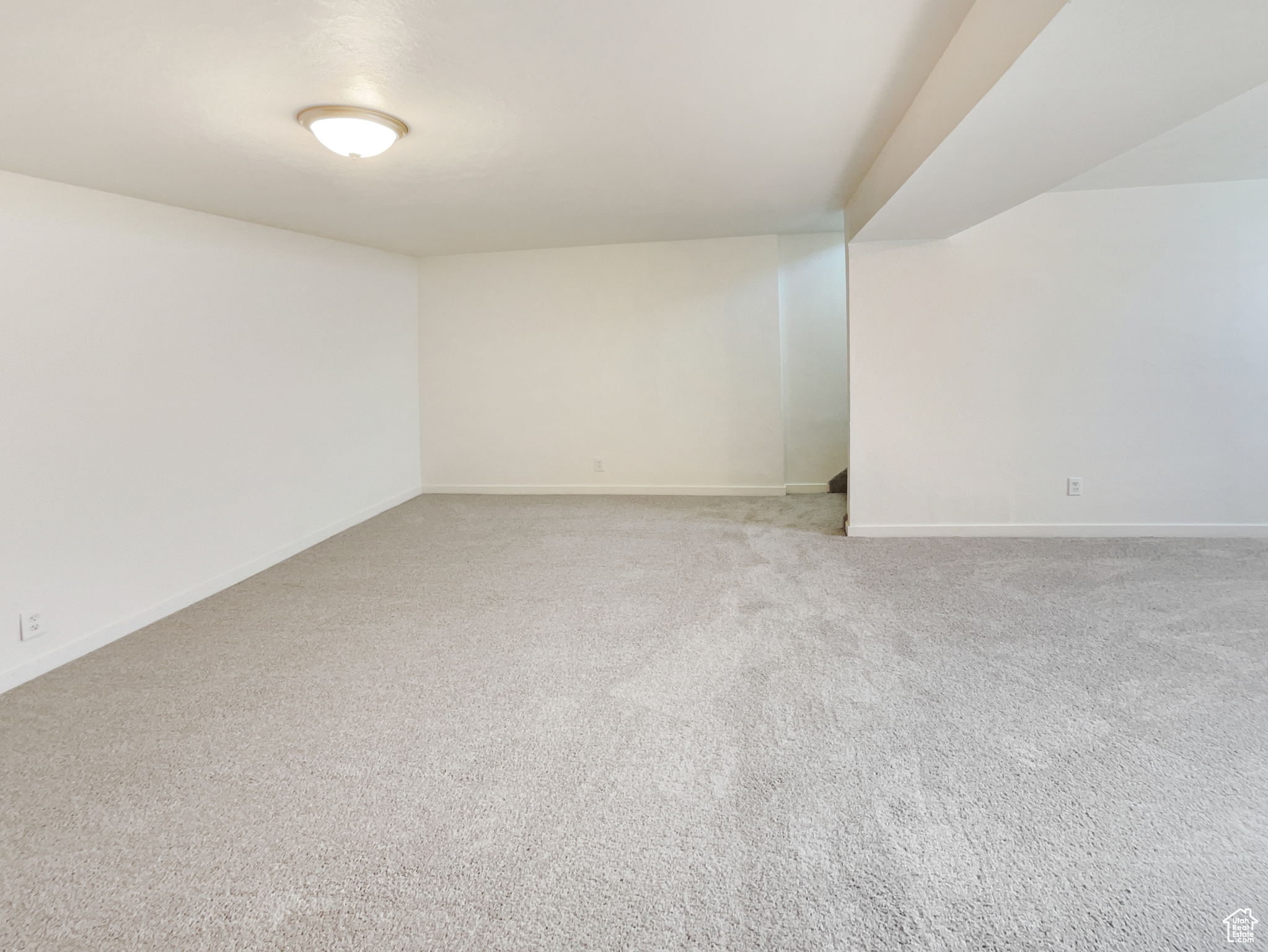 Carpeted empty room featuring baseboards