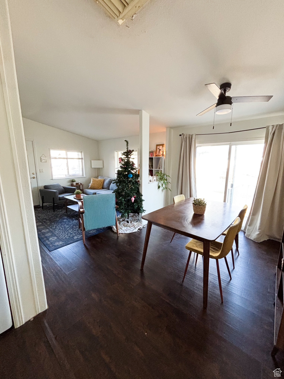 Unfurnished dining area with lofted ceiling, dark wood-style floors, and ceiling fan