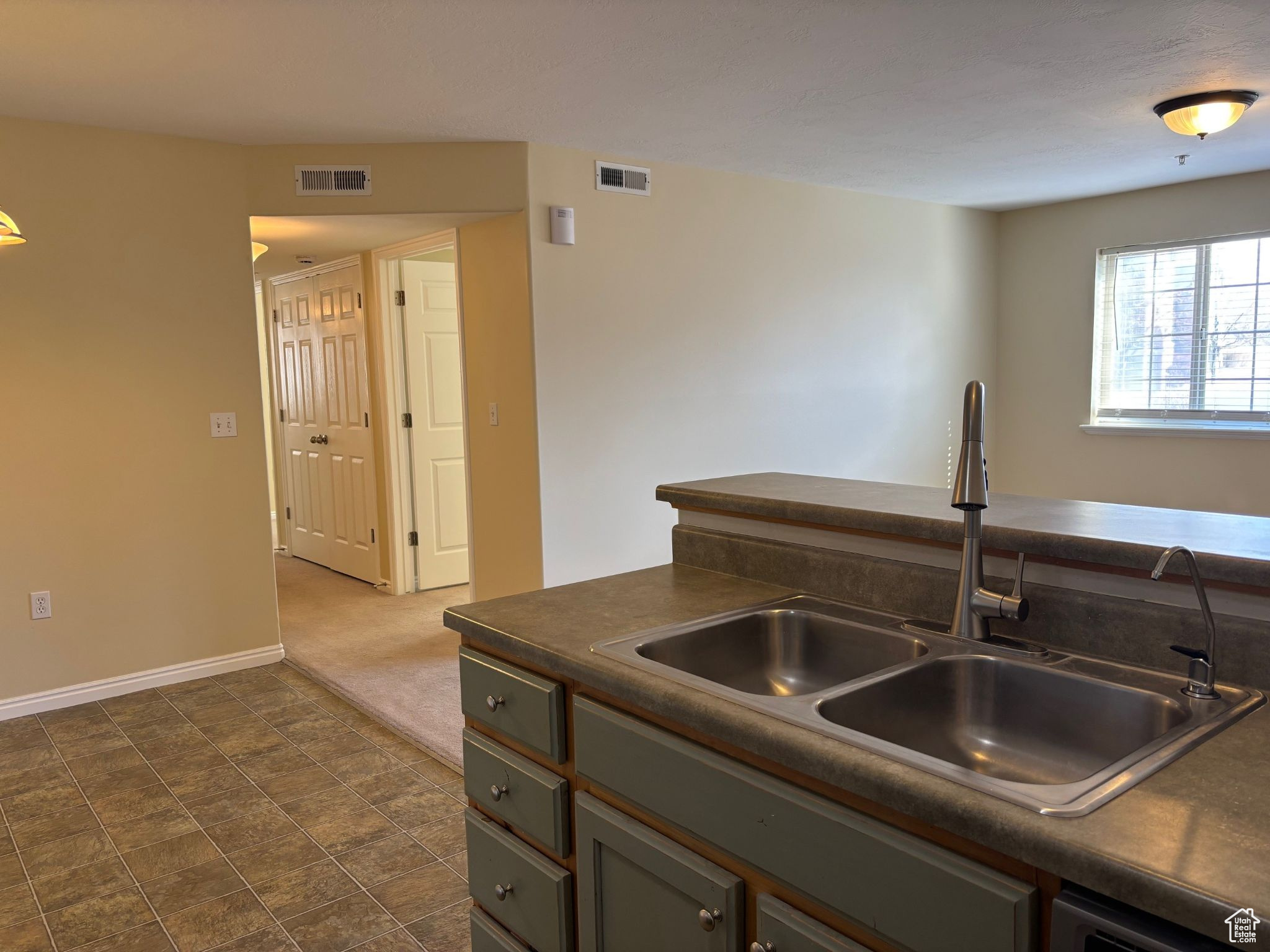 Kitchen featuring dark countertops and a sink