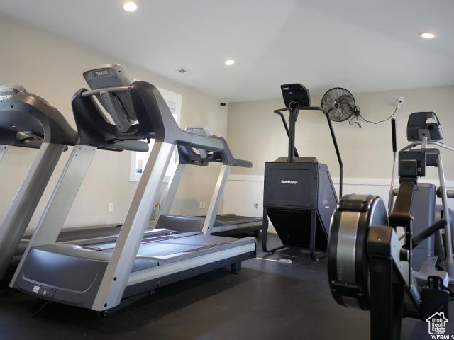 Workout area featuring recessed lighting and wainscoting