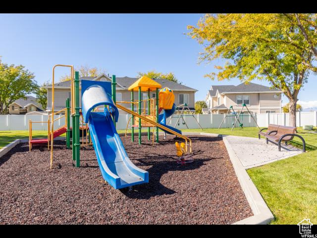 Community jungle gym with a yard and fence