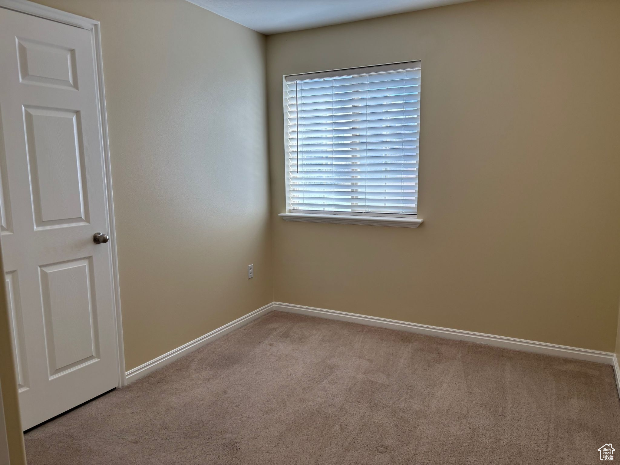Bedroom featuring light-colored carpet and baseboards