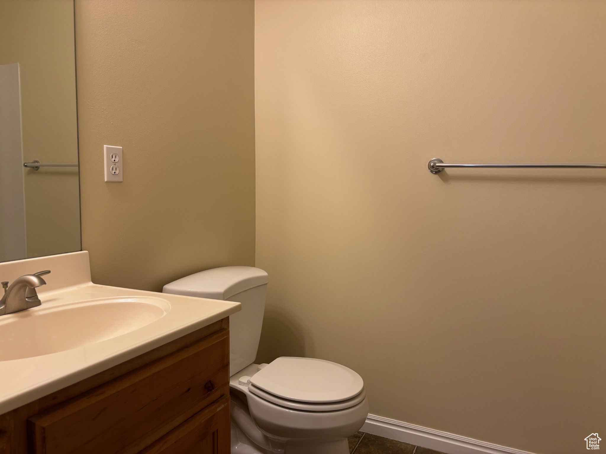 Half bathroom featuring baseboards, vanity, toilet, and tile patterned floors
