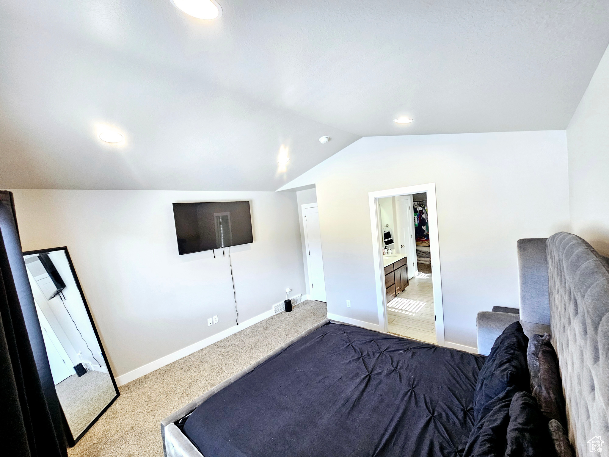 Bedroom featuring lofted ceiling, baseboards, and carpet