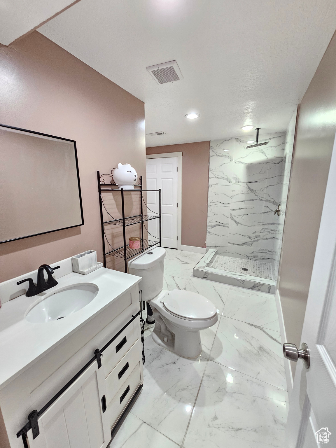 Full bath featuring visible vents, toilet, marble finish floor, vanity, and a shower stall