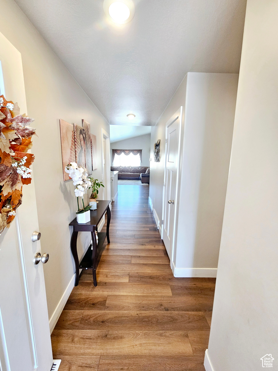 Corridor featuring baseboards and wood finished floors