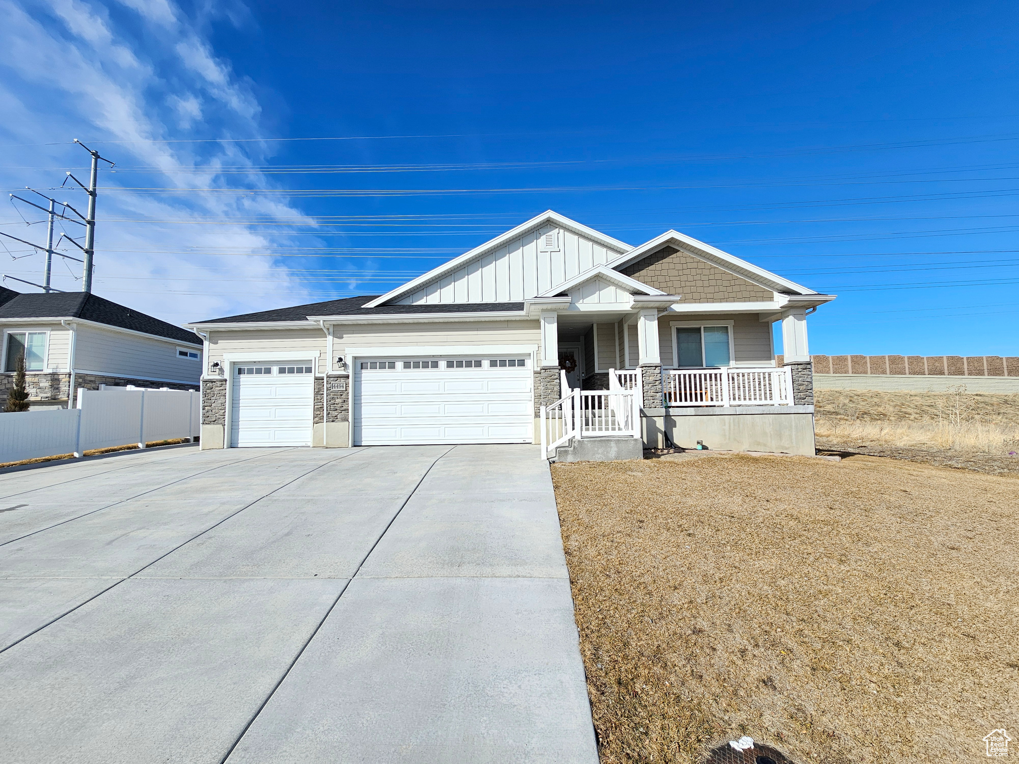 View of front of property featuring board and batten siding, concrete driveway, covered porch, and a garage