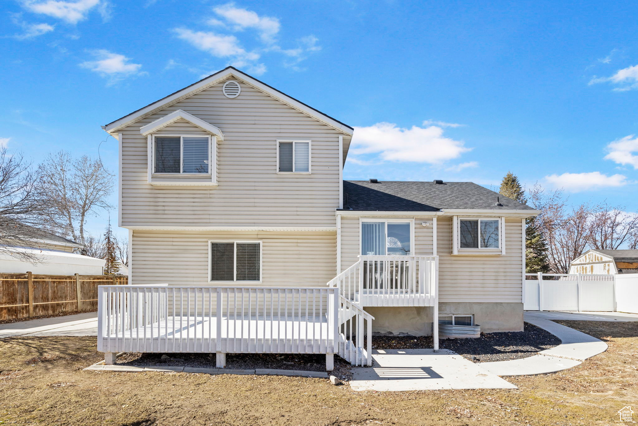 Back of property featuring fence and a wooden deck