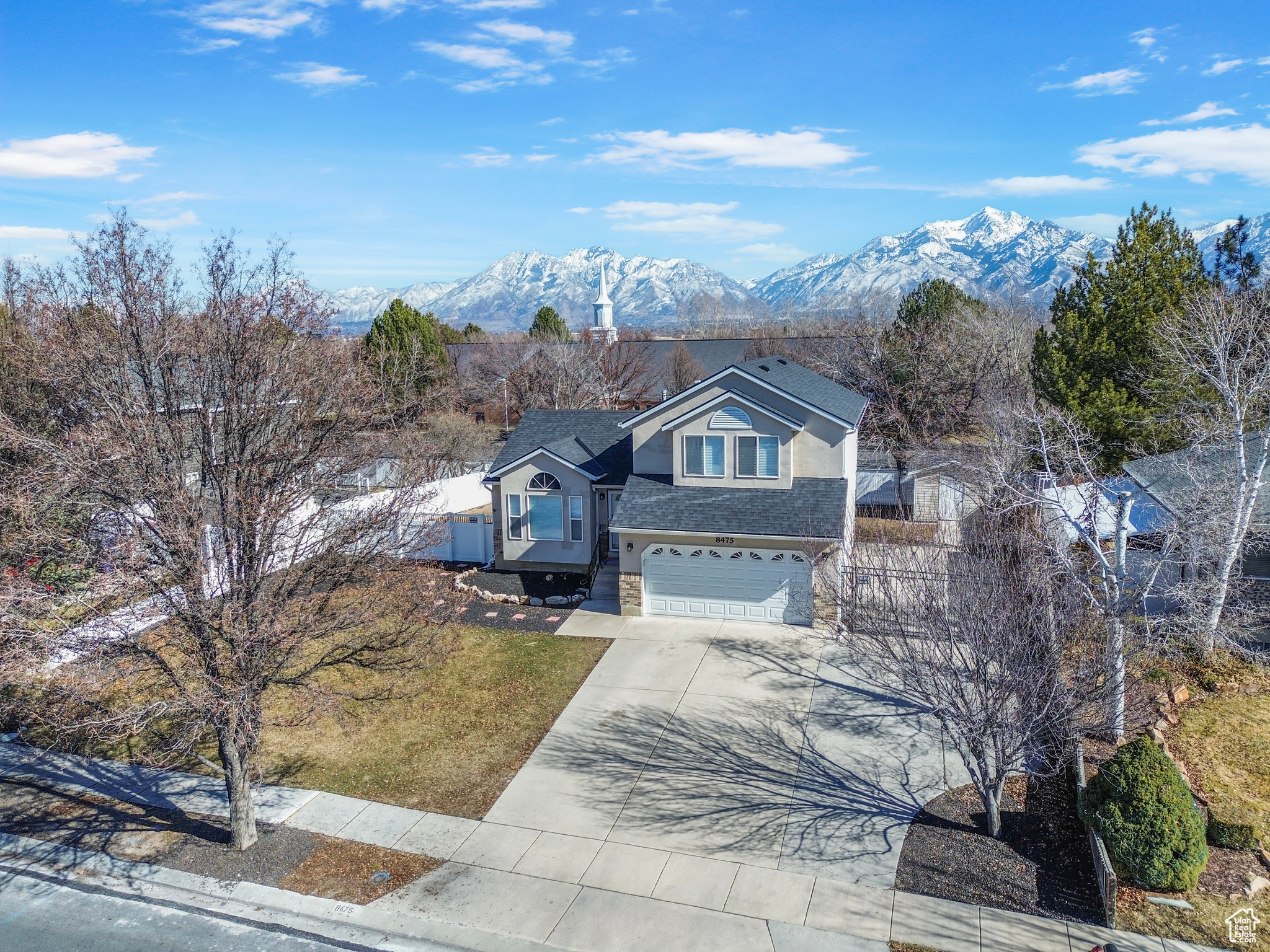 Traditional-style home with driveway, a shingled roof, an attached garage, a mountain view, and stucco siding