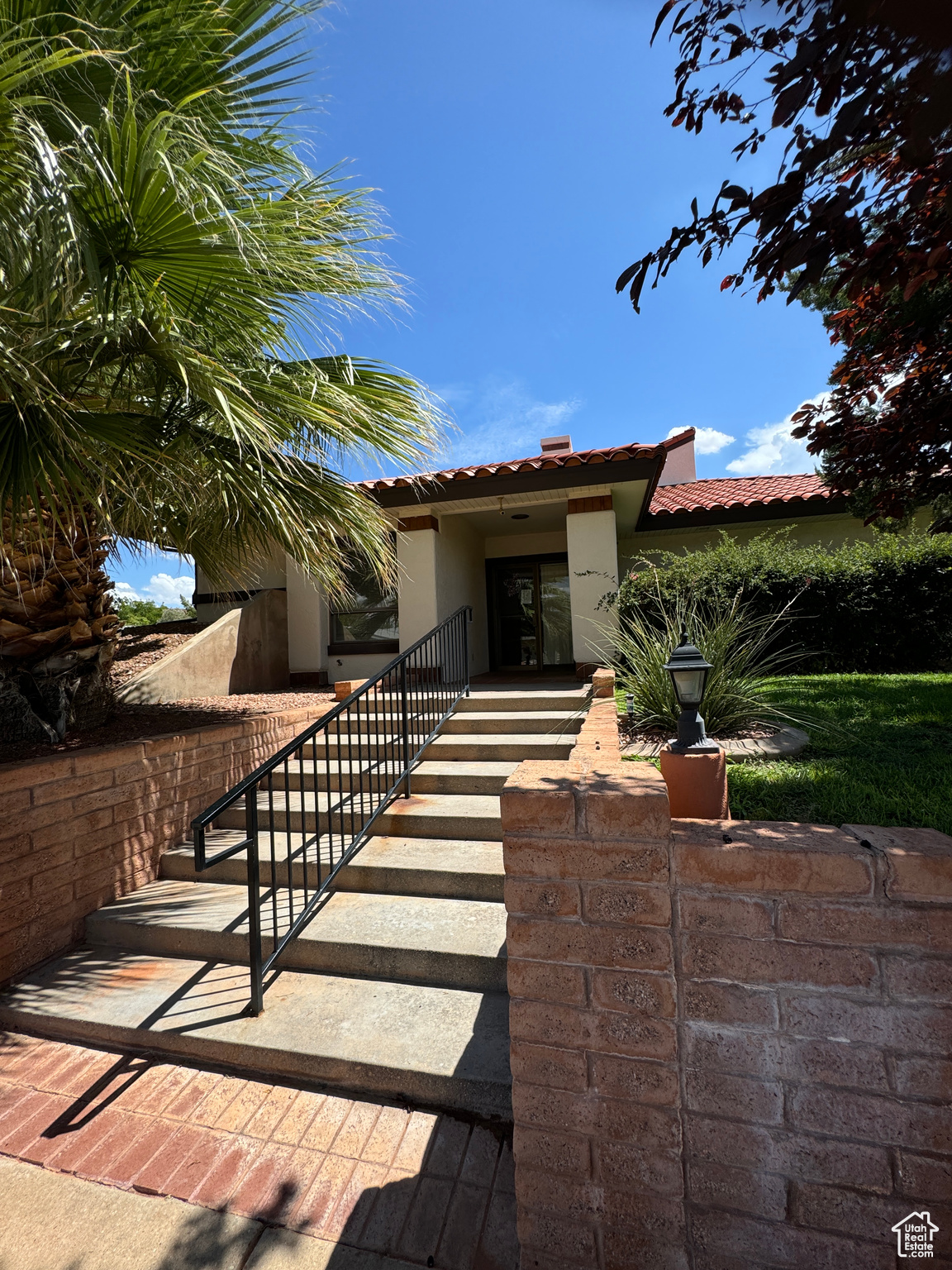 View of front of property featuring a tile roof and stucco siding