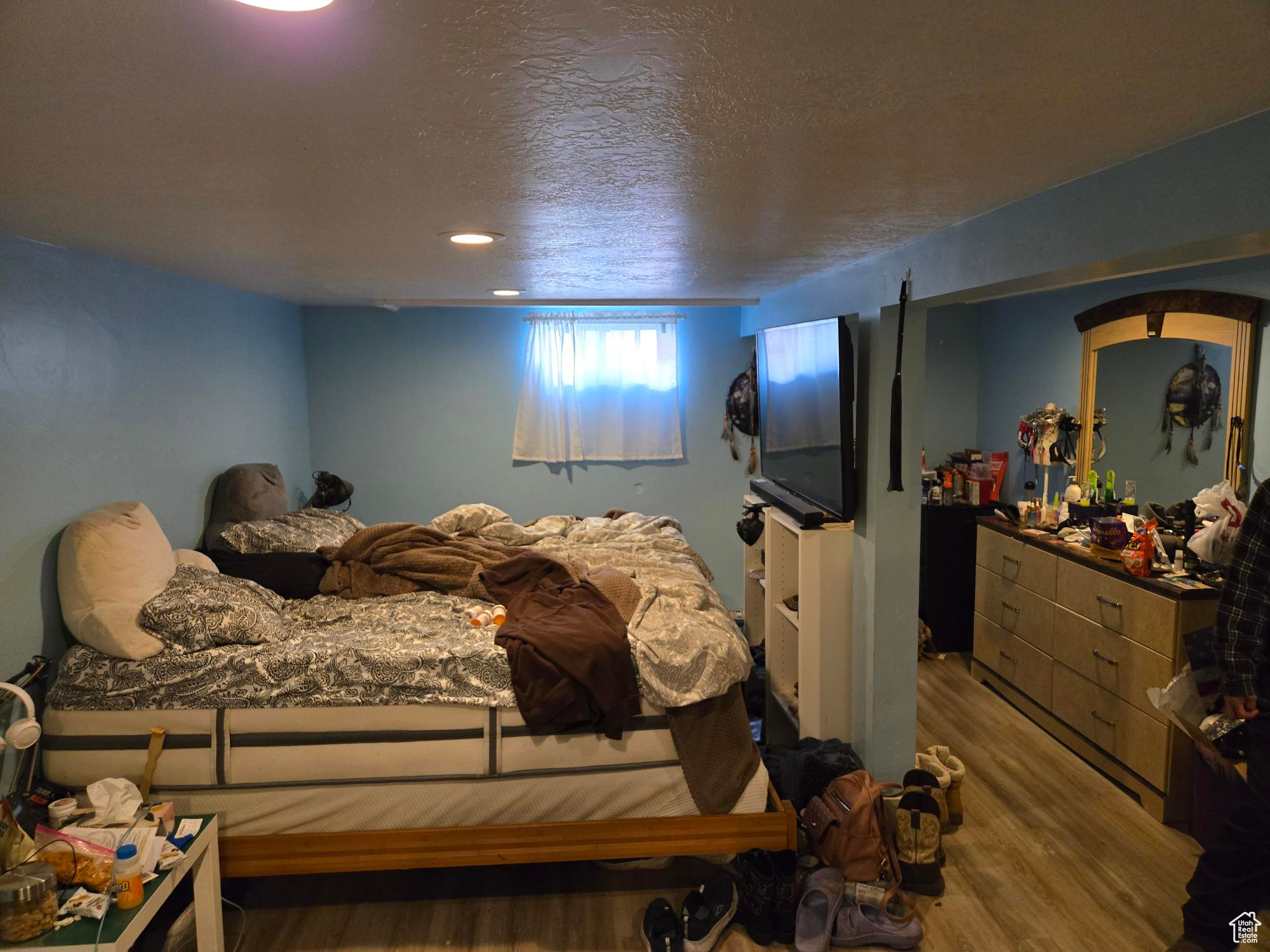 Bedroom featuring a textured ceiling and wood finished floors