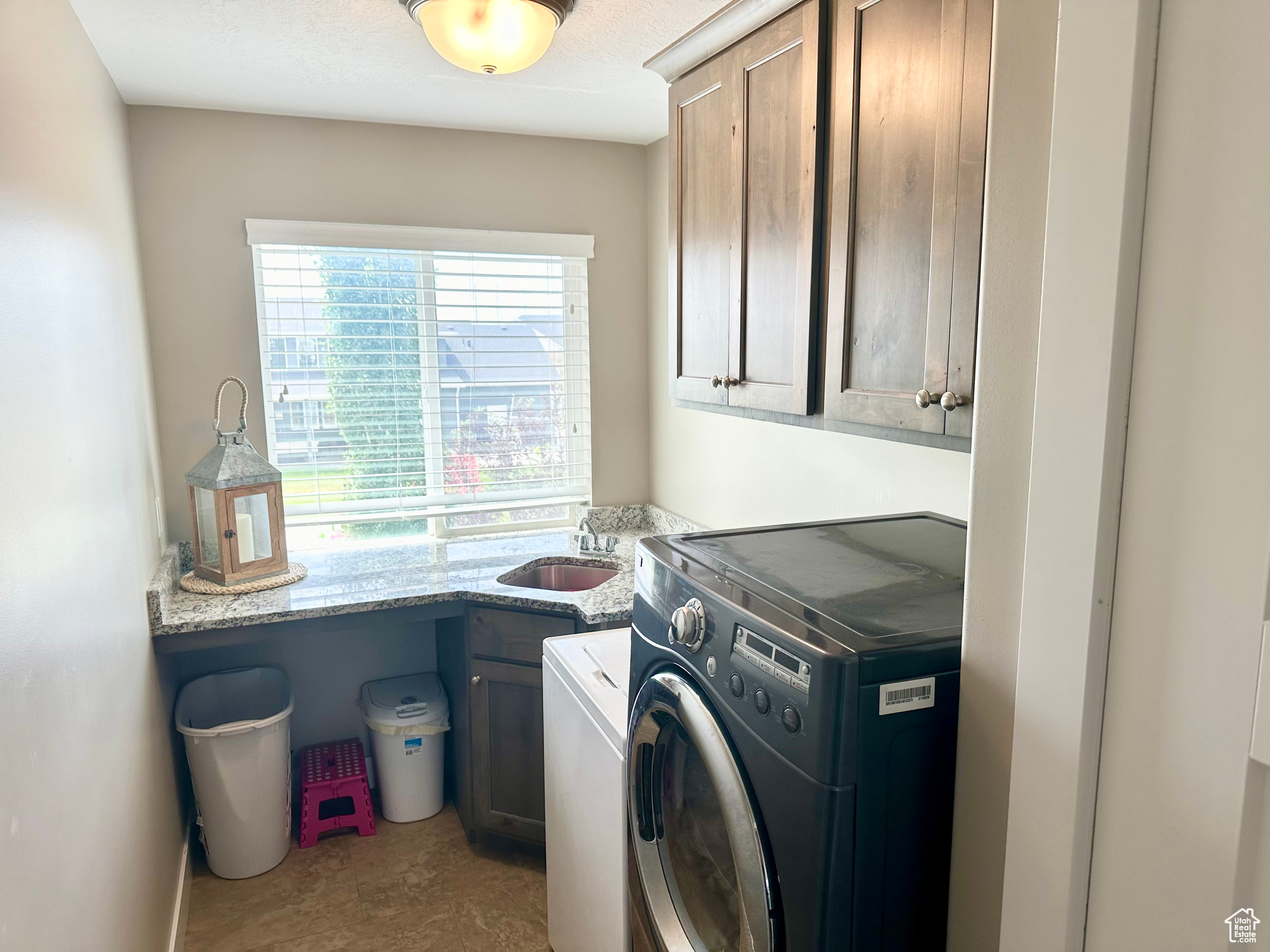Clothes washing area with cabinet space and a sink