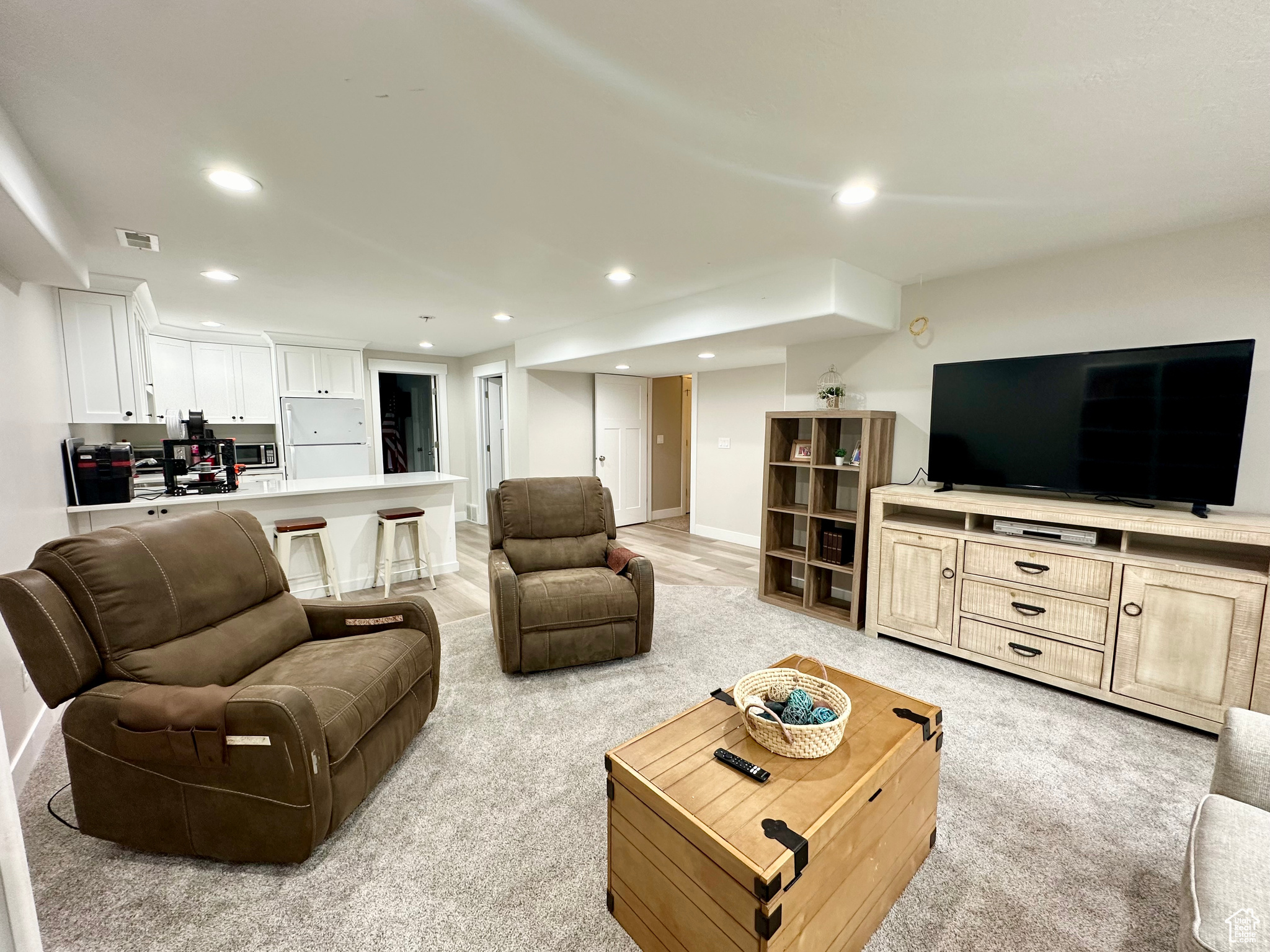 Living area with baseboards, visible vents, and recessed lighting