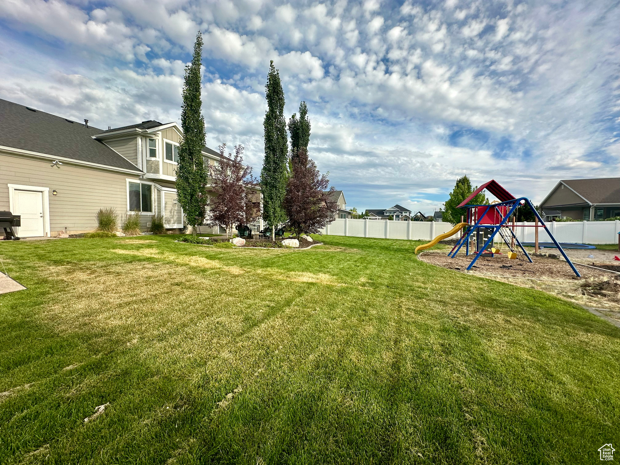 View of yard featuring a playground and a fenced backyard