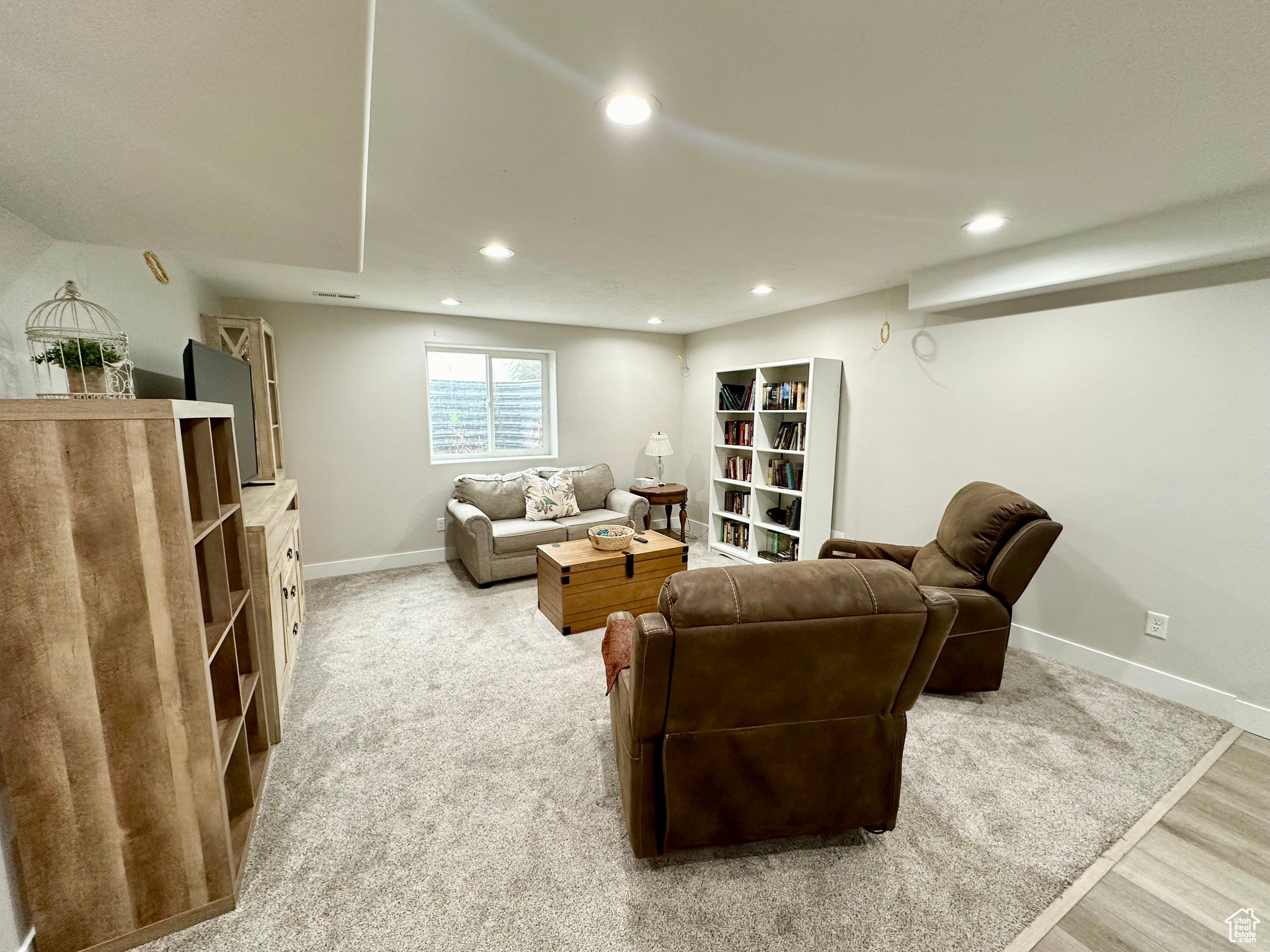 Living area with light wood finished floors, baseboards, and recessed lighting