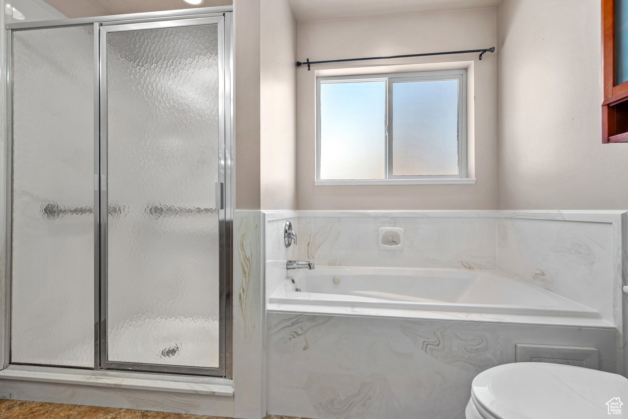 Bathroom featuring toilet, a shower stall, and a bath