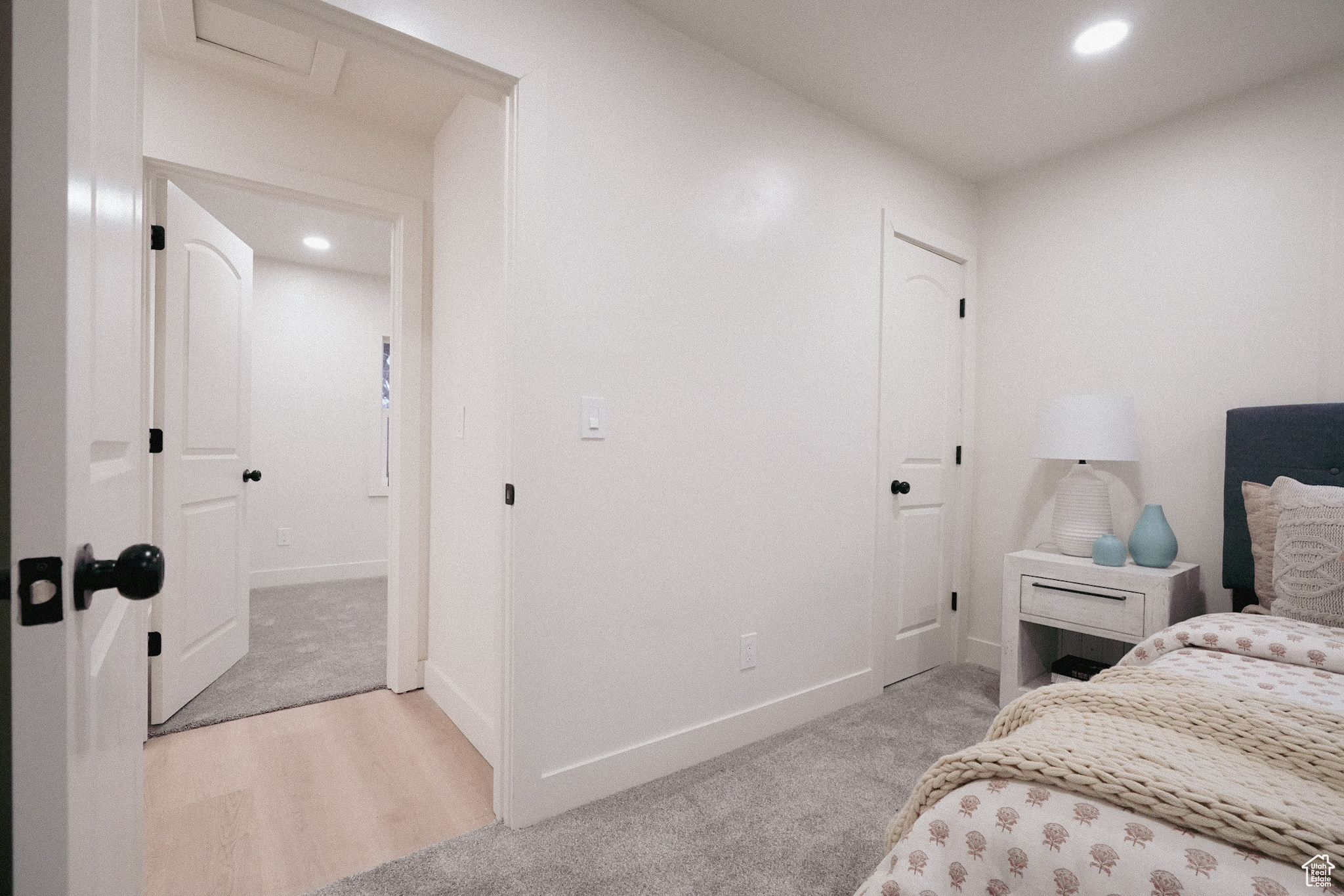 Bedroom with light wood-type flooring, recessed lighting, light carpet, and baseboards