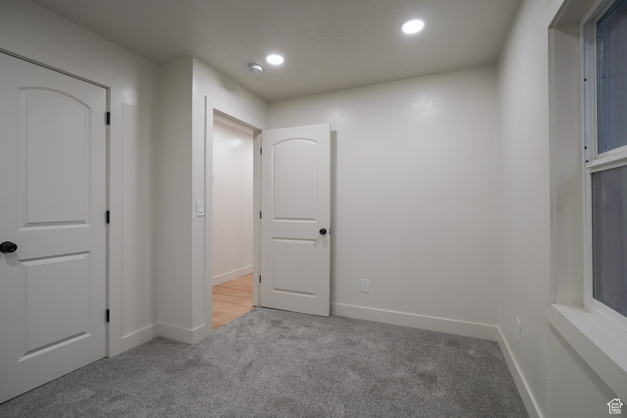 Spare room with recessed lighting, light carpet, and baseboards